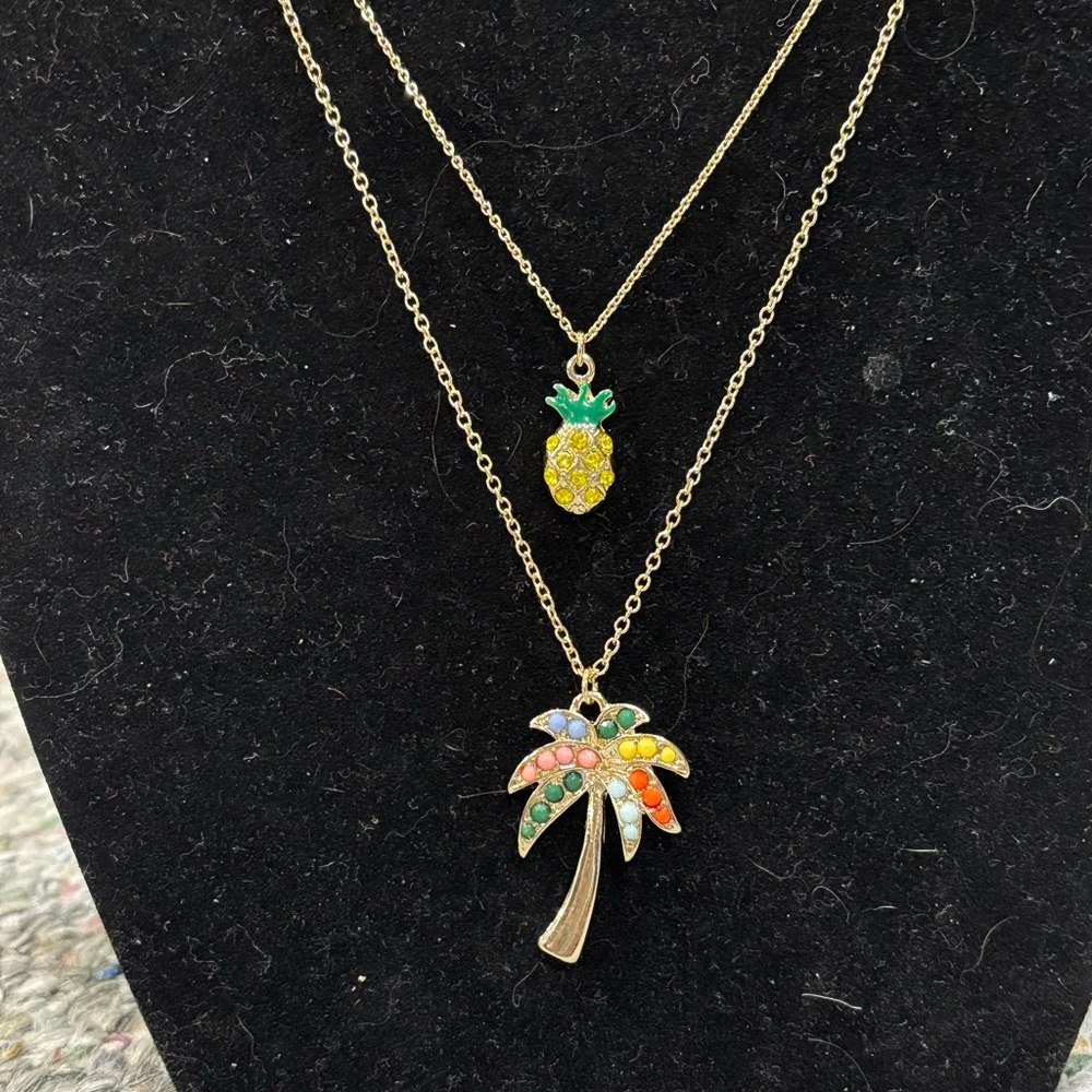 Gold tone palm tree, & pineapple necklaces.Each necklace is 16 to 18 inches long